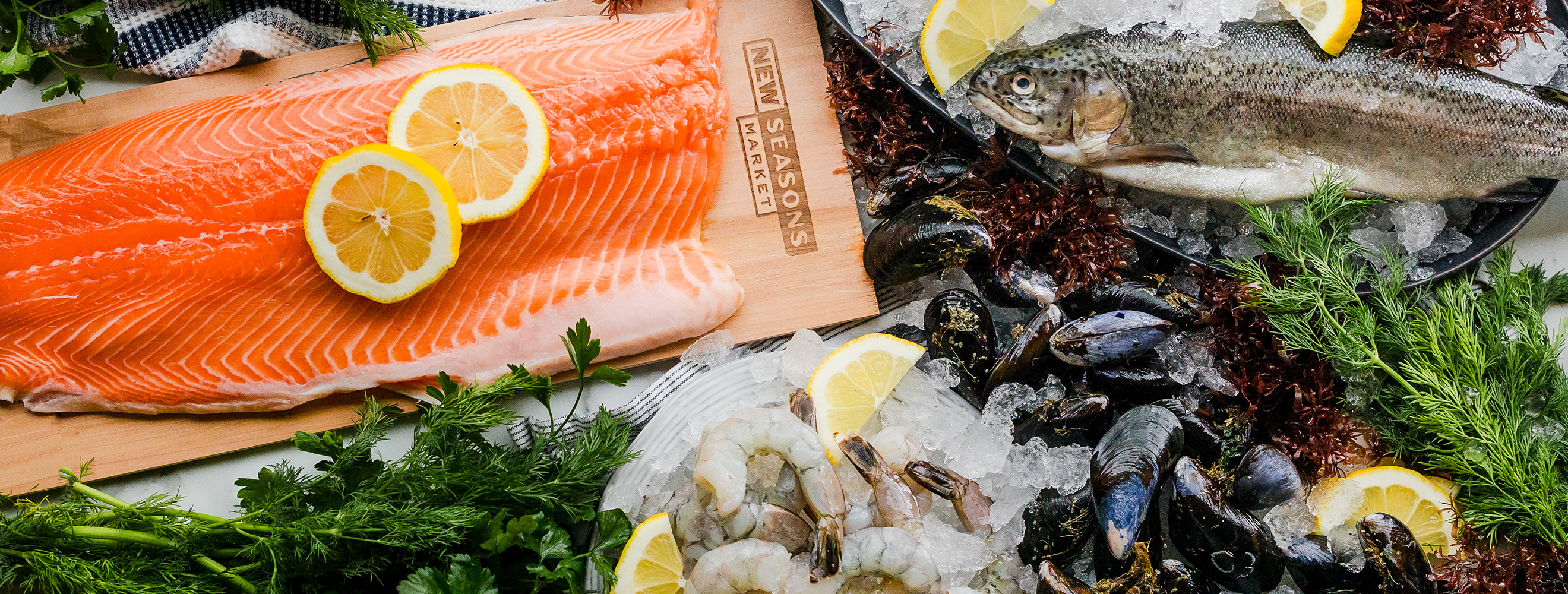 seafood display of salmon filet with lemon slices, shrimp and mussels.