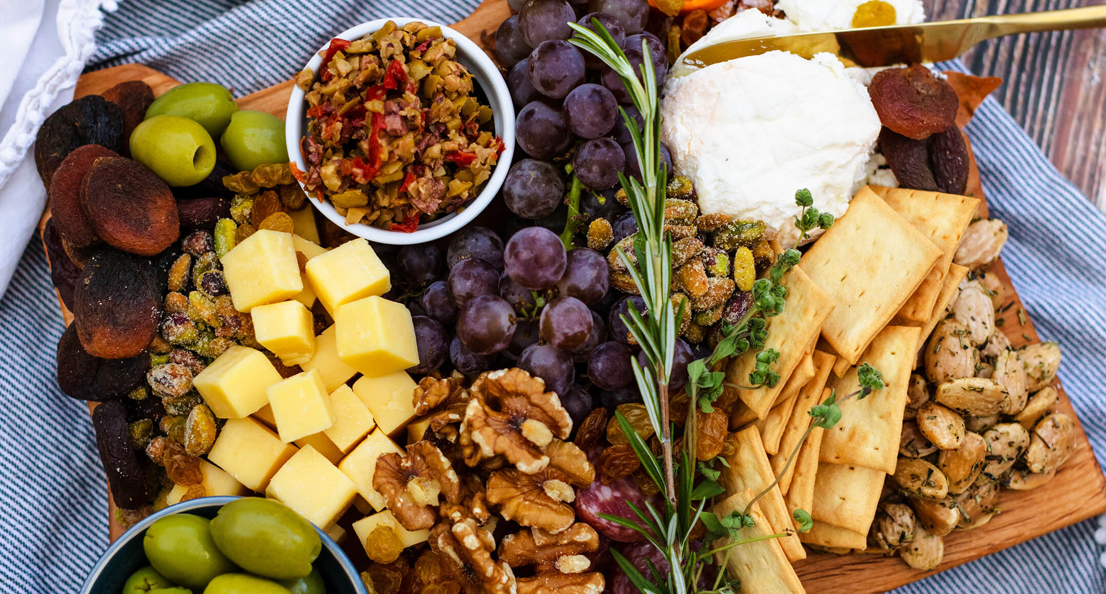 A charcuterie board featuring fruit, nuts, crackers, and local Oregon cheese.