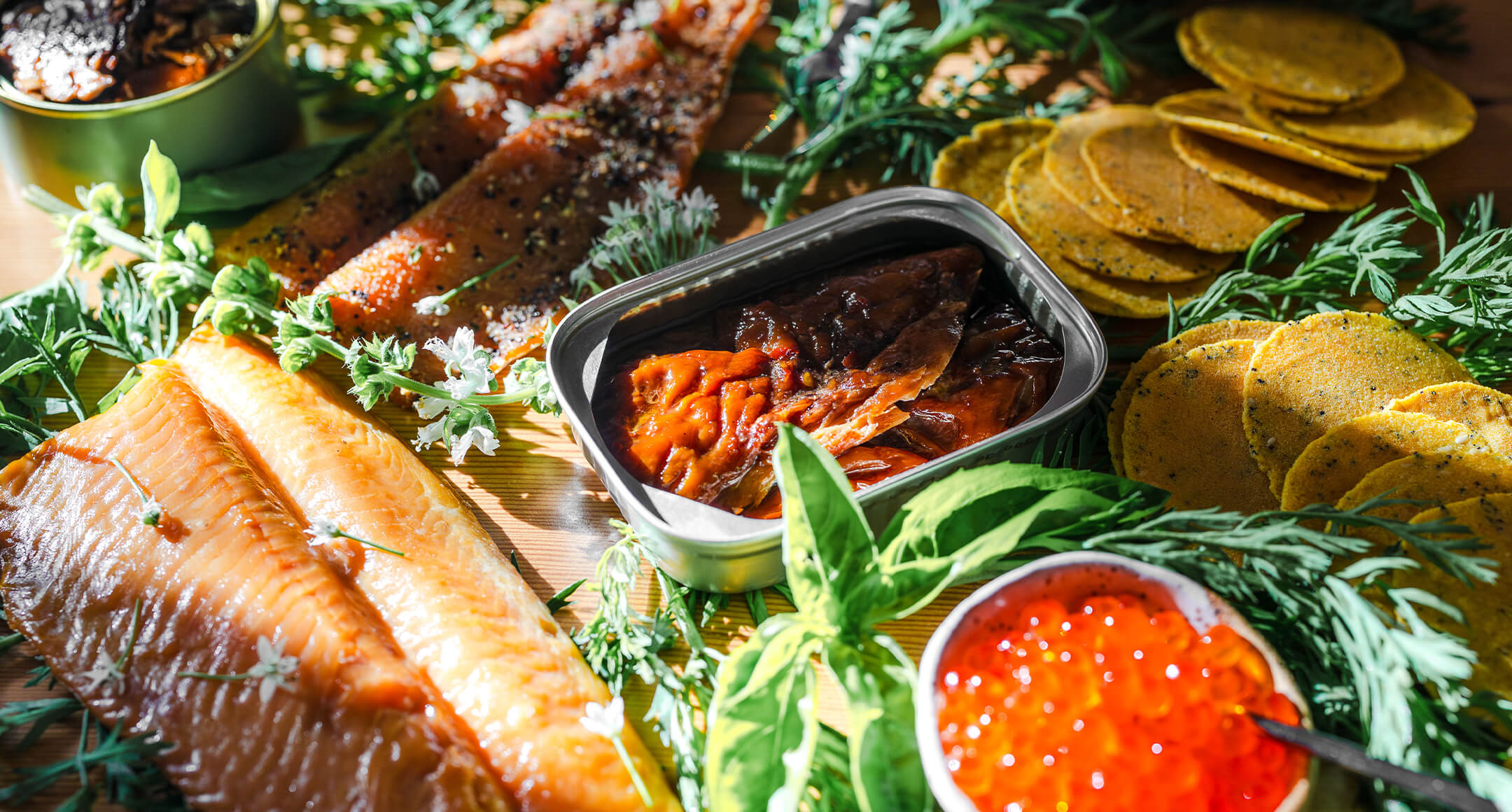 A holiday seafood spread featuring tinned fish, smoked fish, and trout roe.