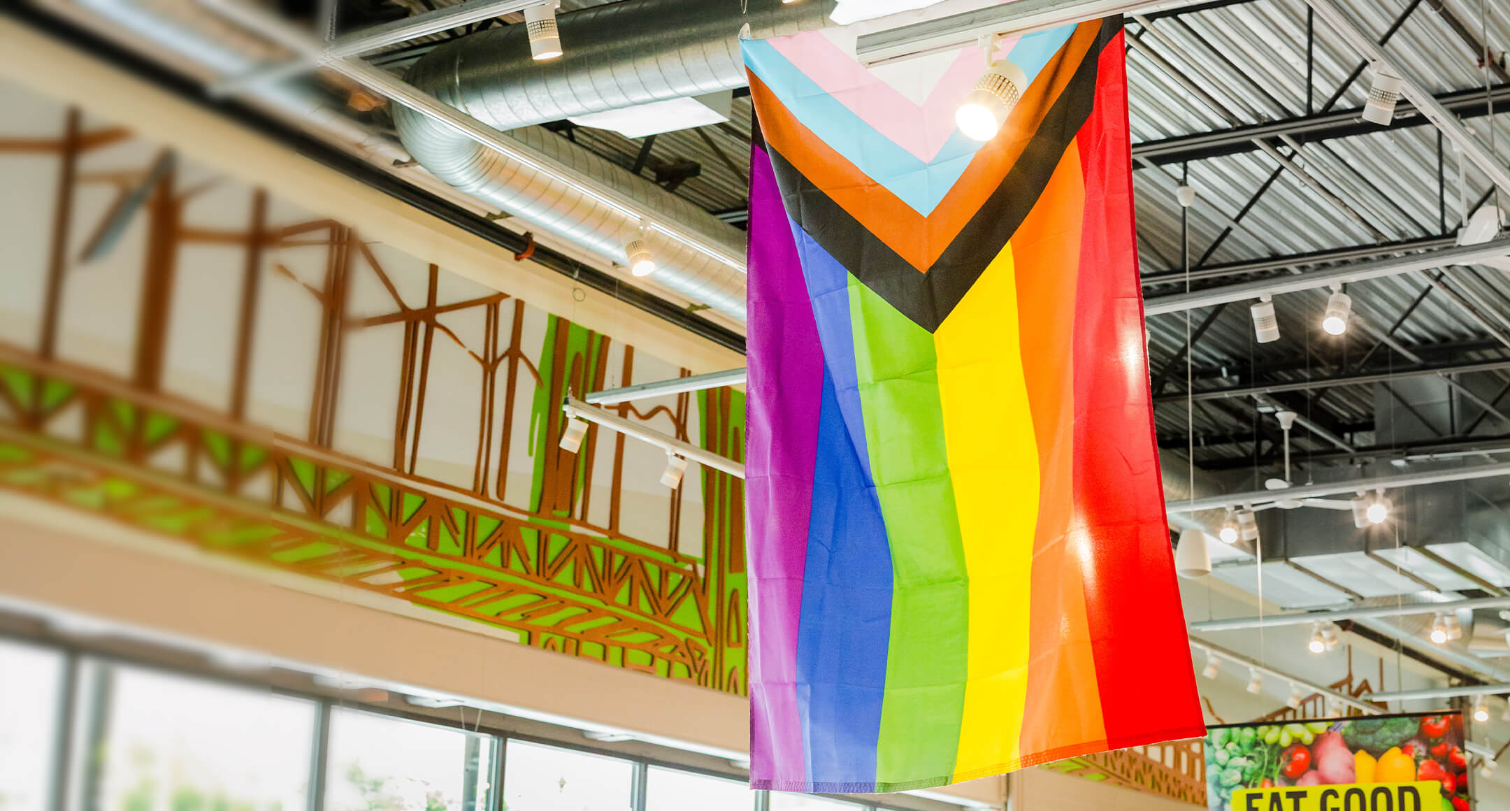 A Pride flag hanging from the ceiling of New Seasons Market.