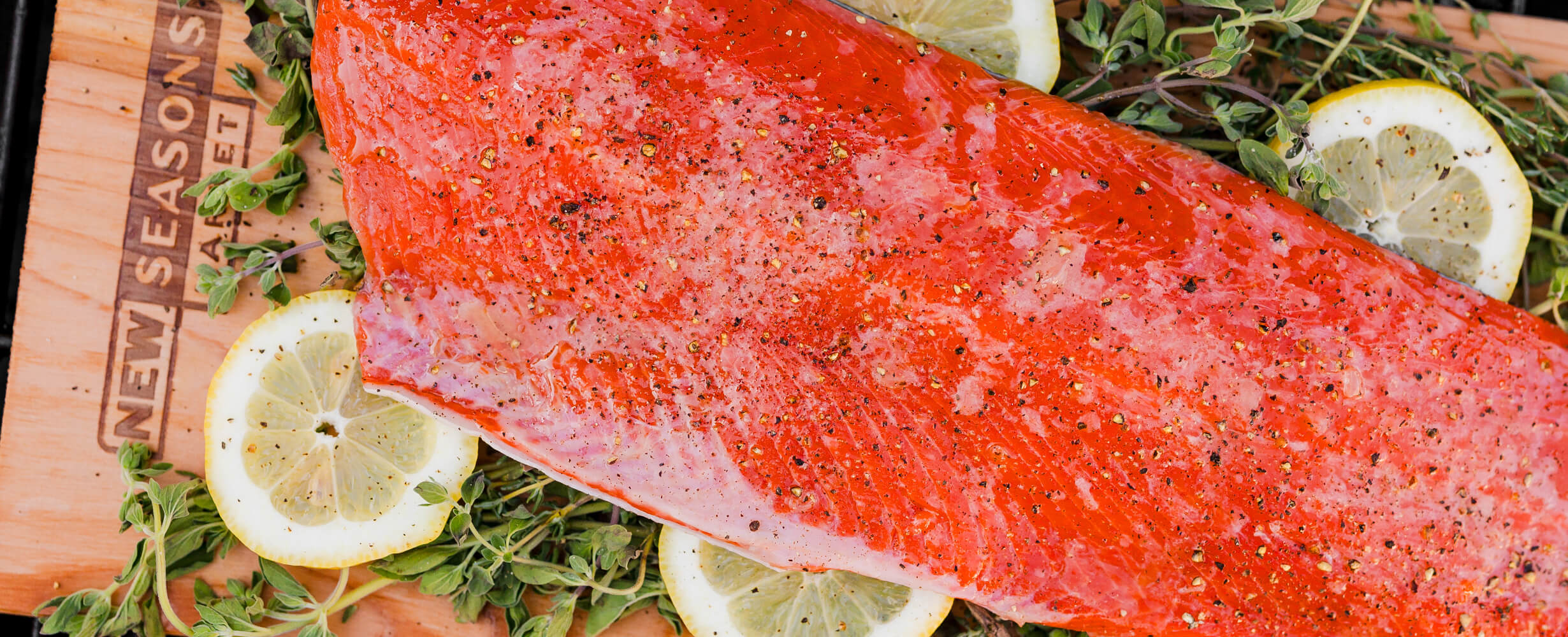 A sockeye salmon fillet on a wood board with lemon