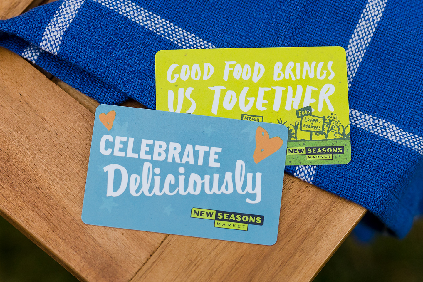 Two New Seasons gift cards on a wooden surface