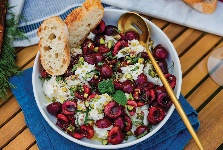 A cherry and burrata salad in a bowl.