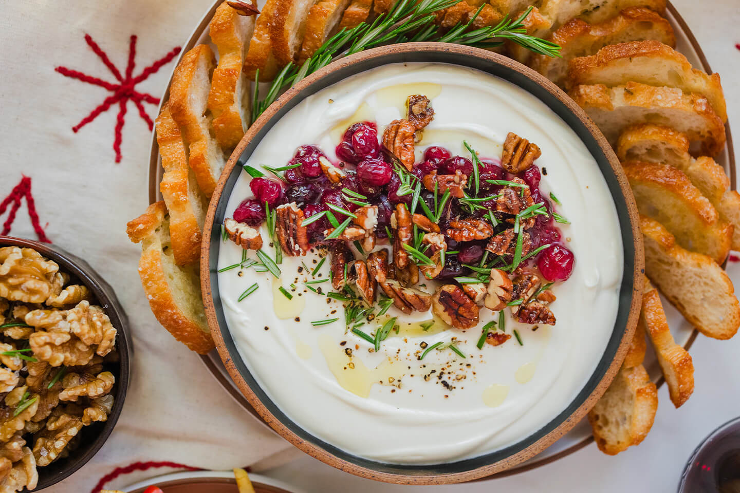 Whipped goat cheese appetizer topped with rosemary, walnuts and dried cranberries.