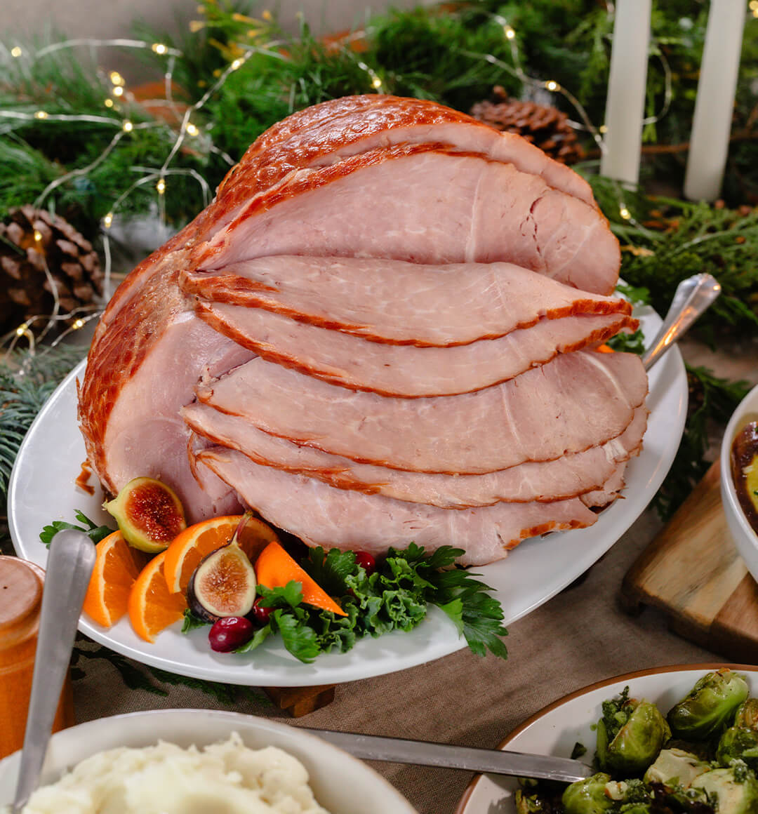 A sliced ham on a serving platter