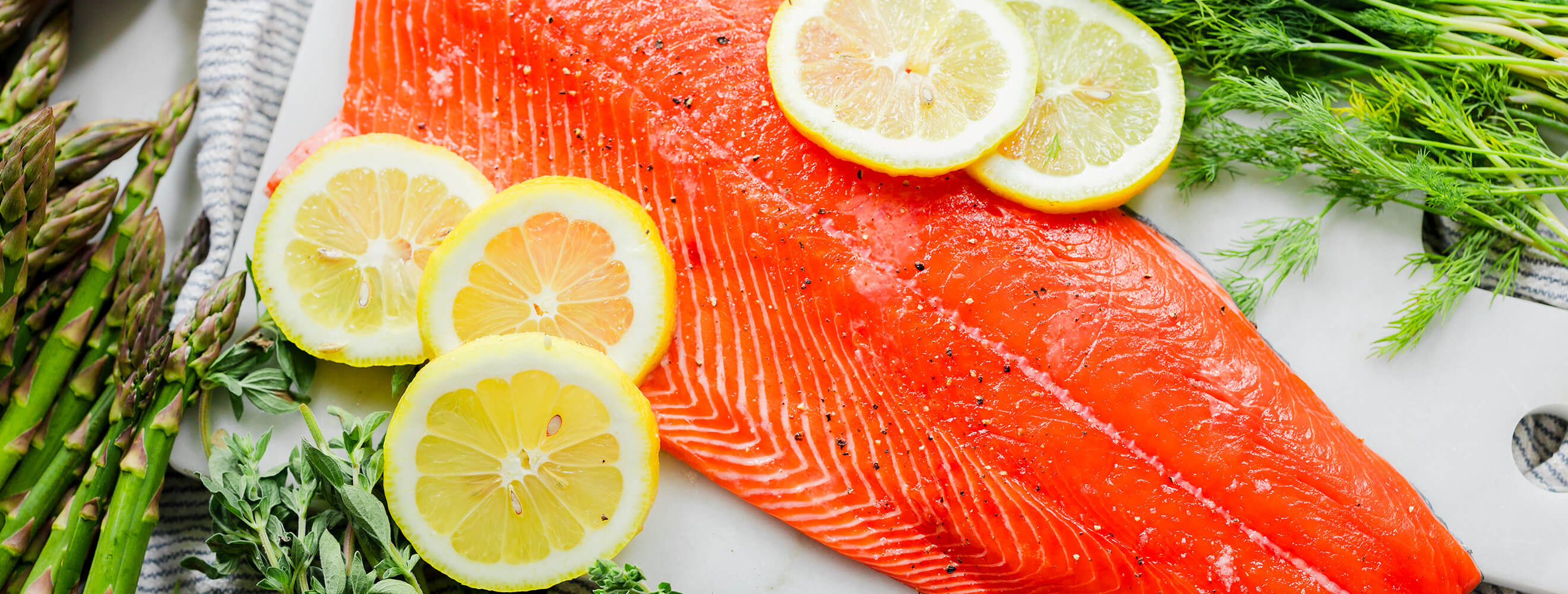 a raw filet of salmon with lemon slices