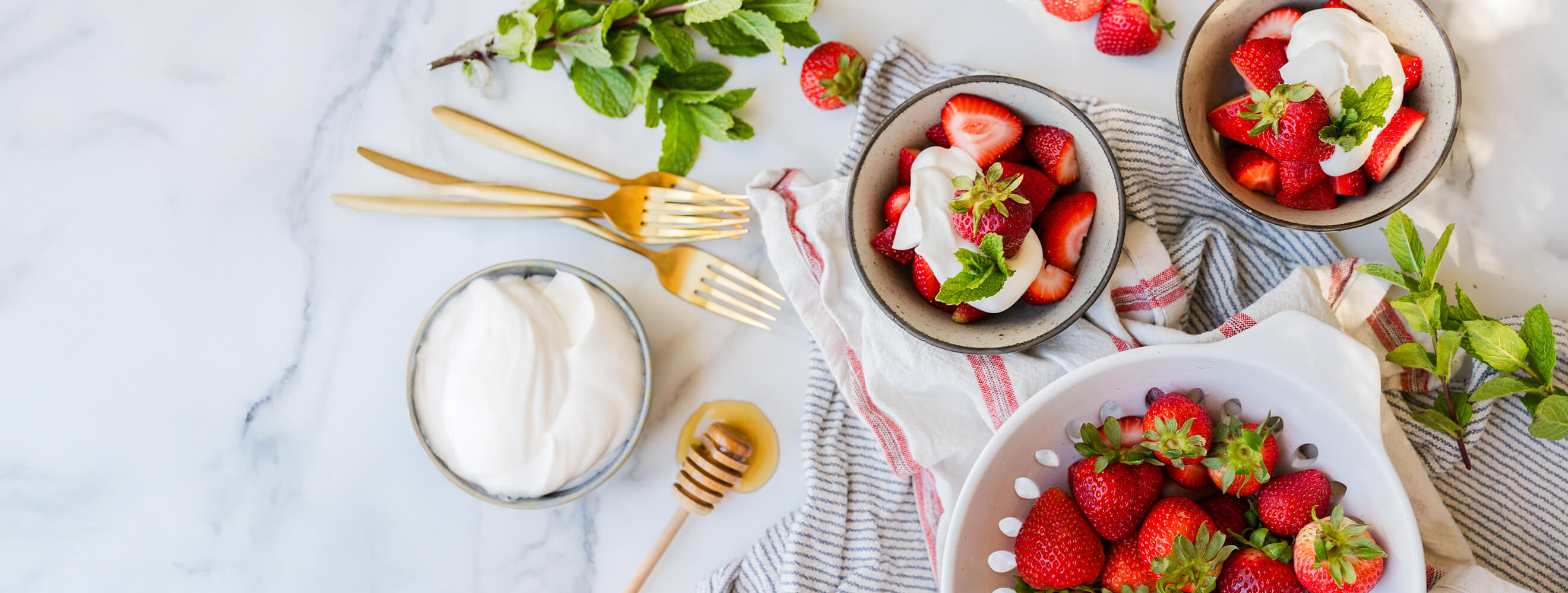 Bowls of strawberries topped with cream