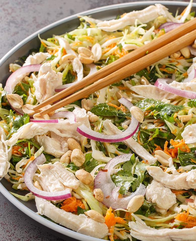chicken salad bowl with vegetables and chopsticks.