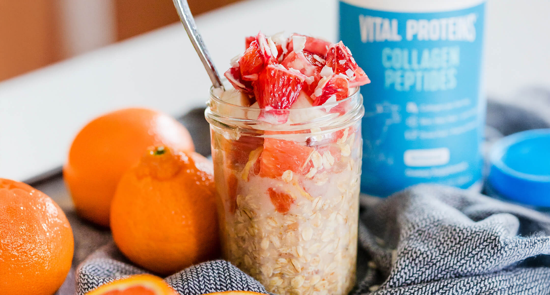 A jar filled with overnight oats and topped with pits of orange.