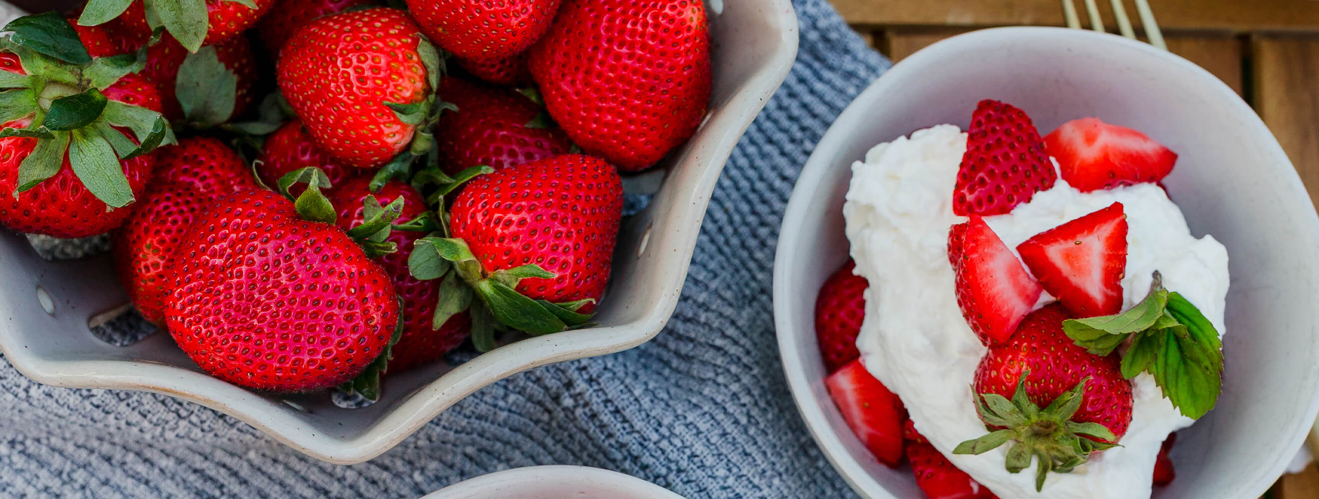 Strawberries in a bowl with whipped cream.
