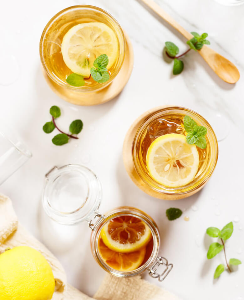 Two honey bee cocktails garnished with a slice of lemon