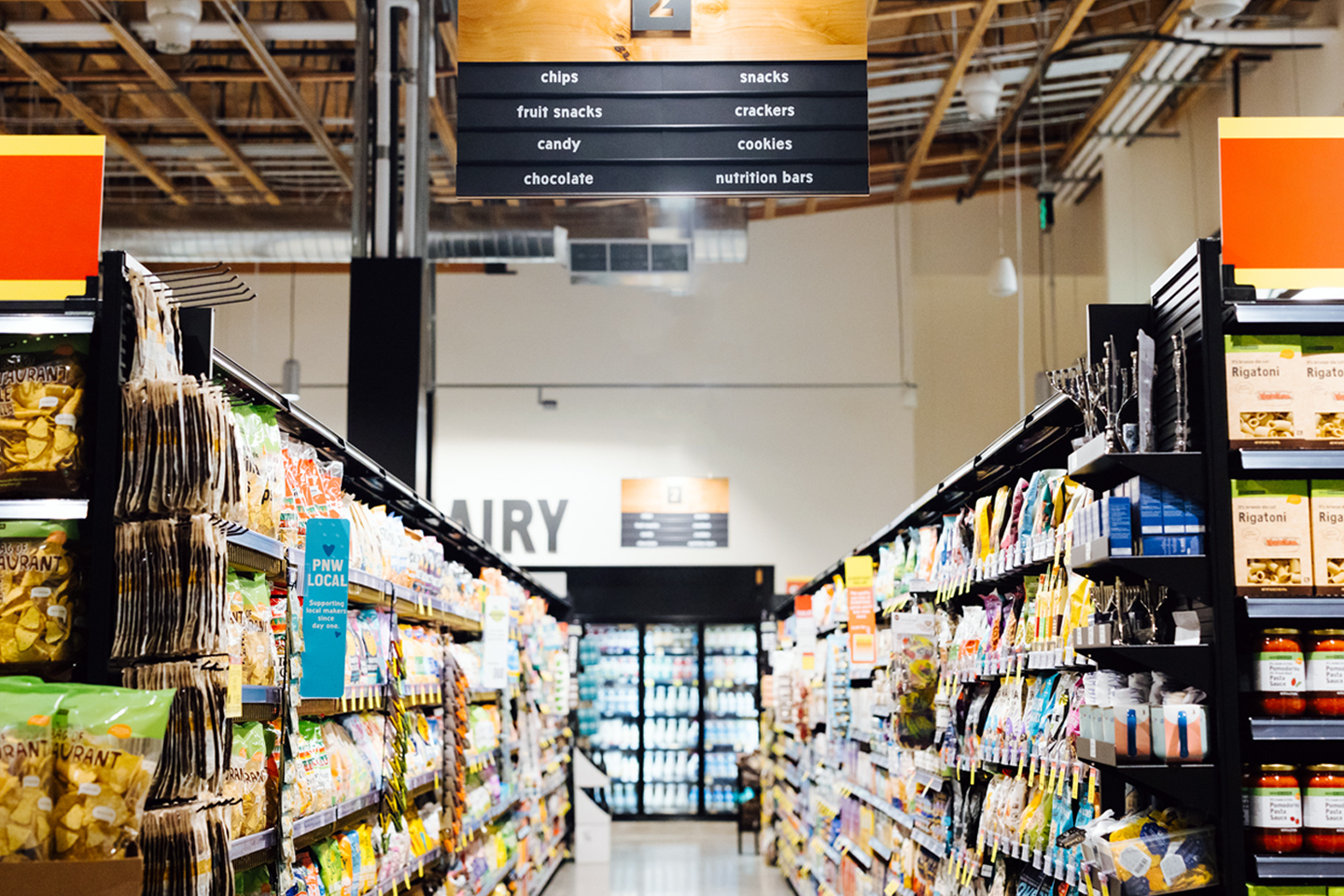 a view down a grocery aisle at New Seasons Market showing a variety of packaged grocery items.