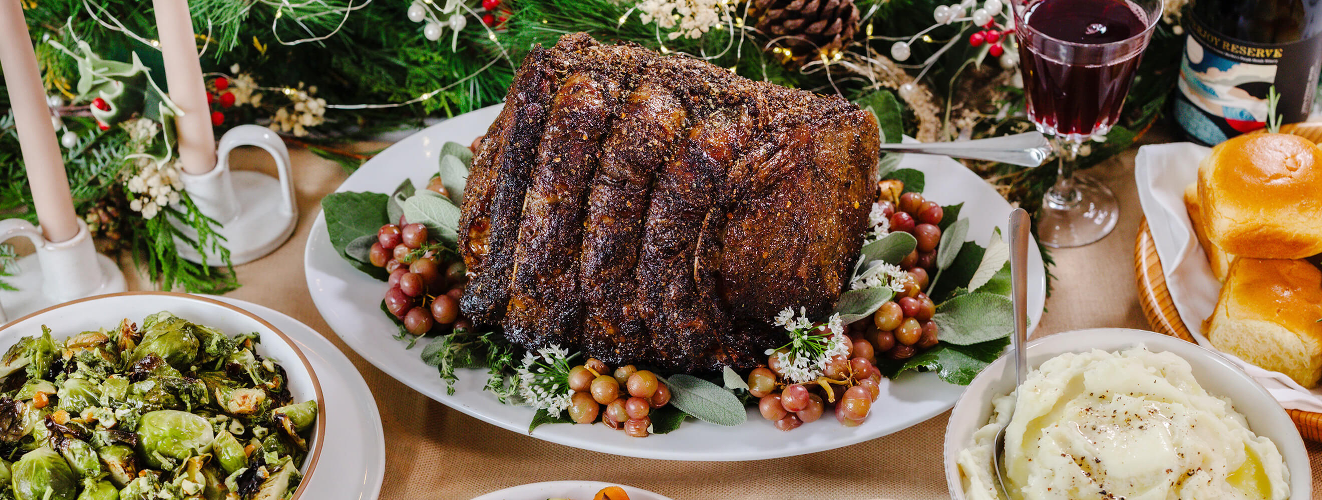 a beef prime rib roast on a holiday platter on a festive table