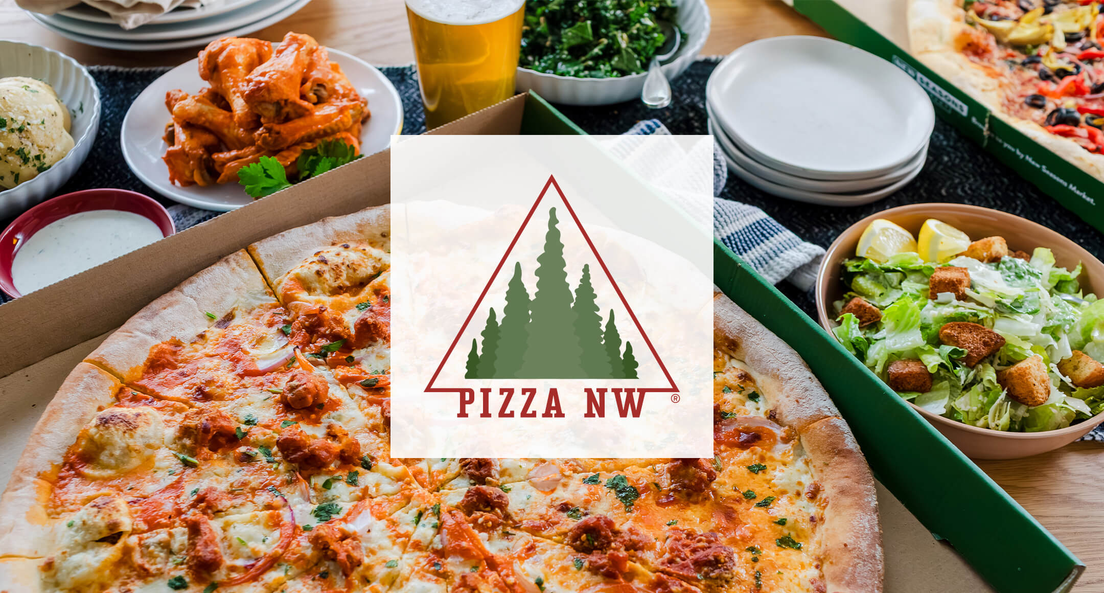 New Seasons PizzaNW logo with an image of artisan pizza in a box, chicken wings, and side salads.