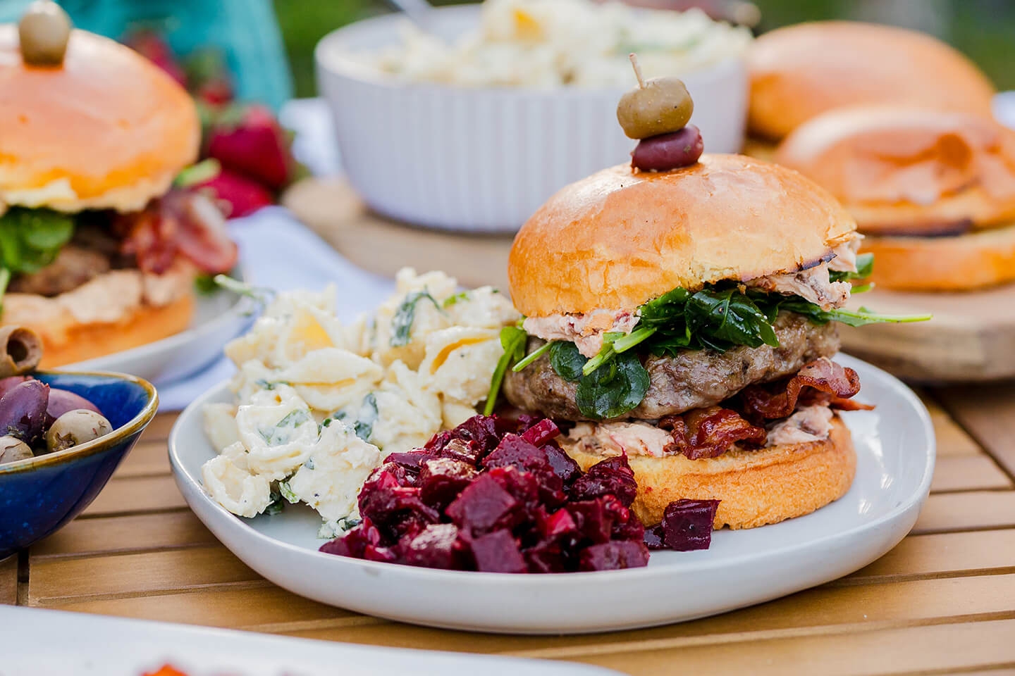 A grilled burger with seasonal deli sides.