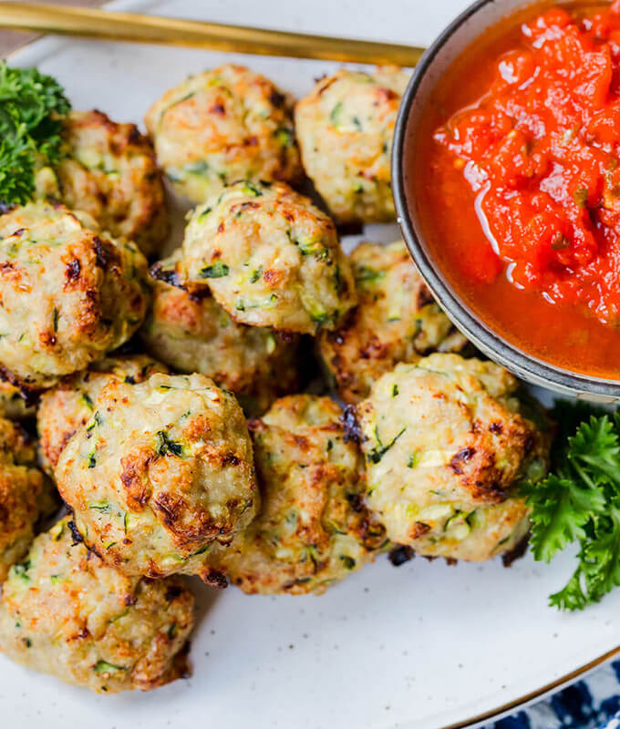 a healthy meal plated with turkey meatballs and a red tomato sauce