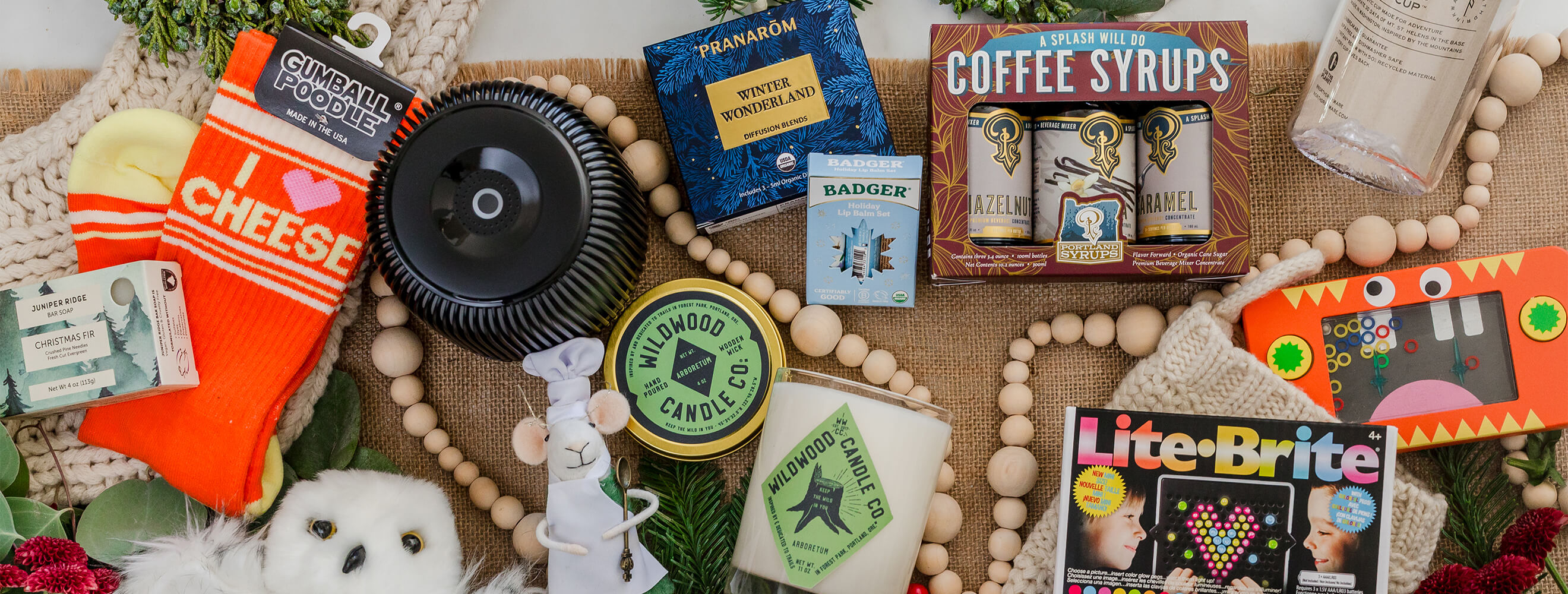 A variety of gifts such as candles, stuffed animals, toys, socks and syrups.