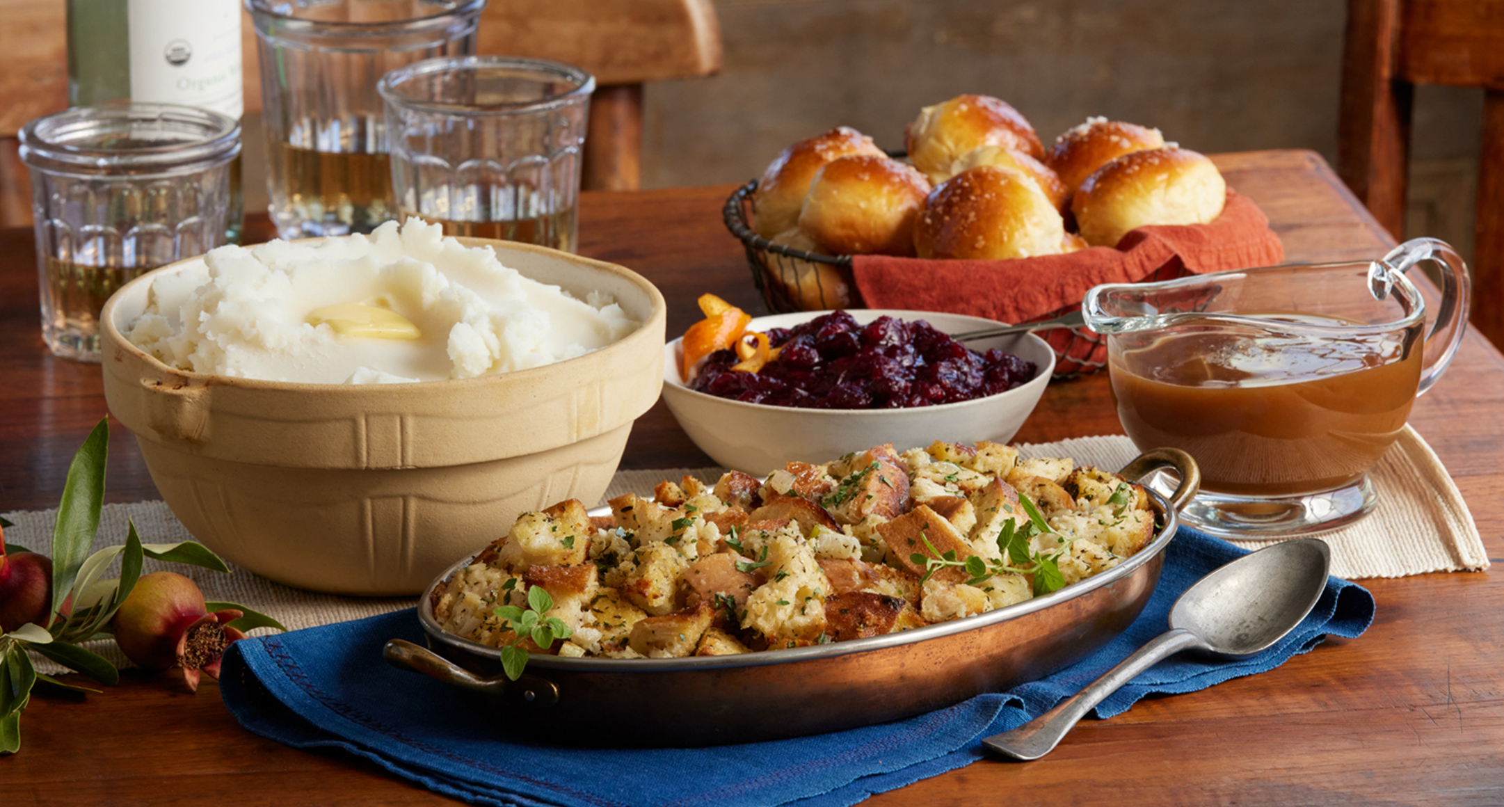 A festive holiday table with ready-to-eat sides, including mac & cheese, roasted Brussel sprouts, and mashed sweet potatoes.