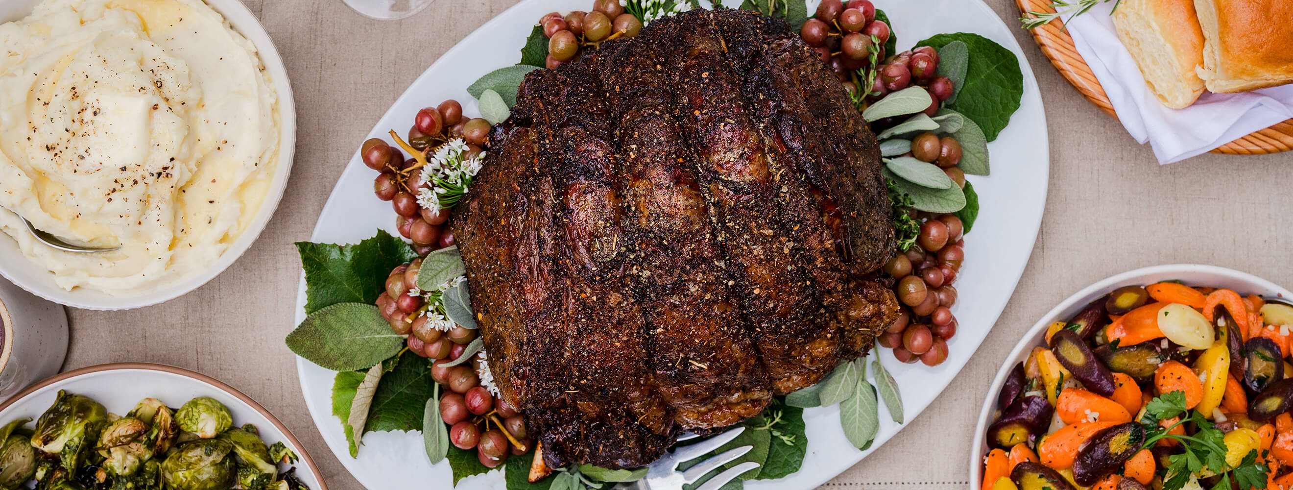 a beef prime rib roast on a holiday platter in an overhead shot