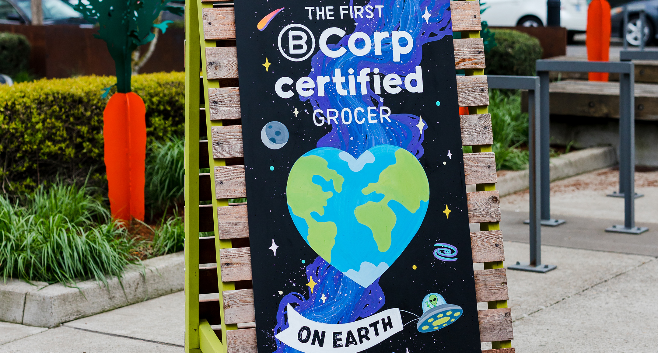 A colorful A-frame sign featuring a heart-shaped Earth.