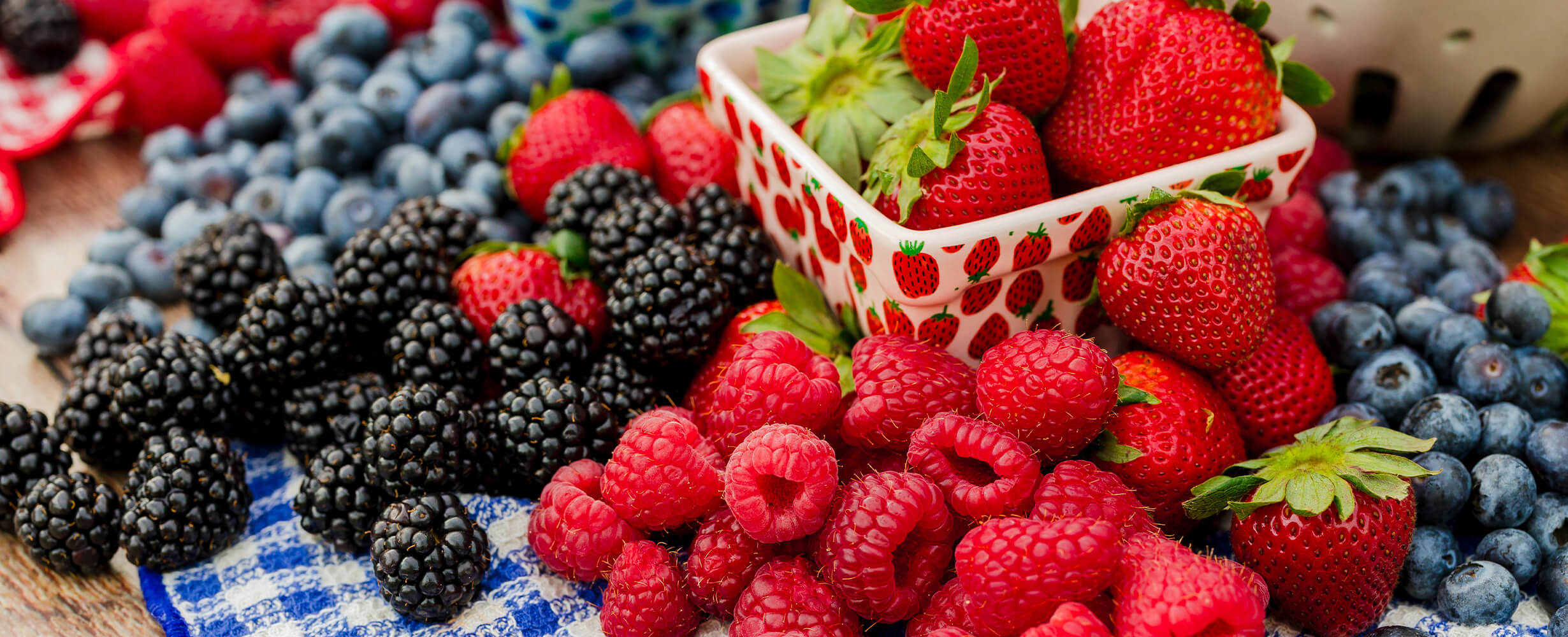 An assortment of local summer berries including raspberries, strawberries, blueberries, and blackberries