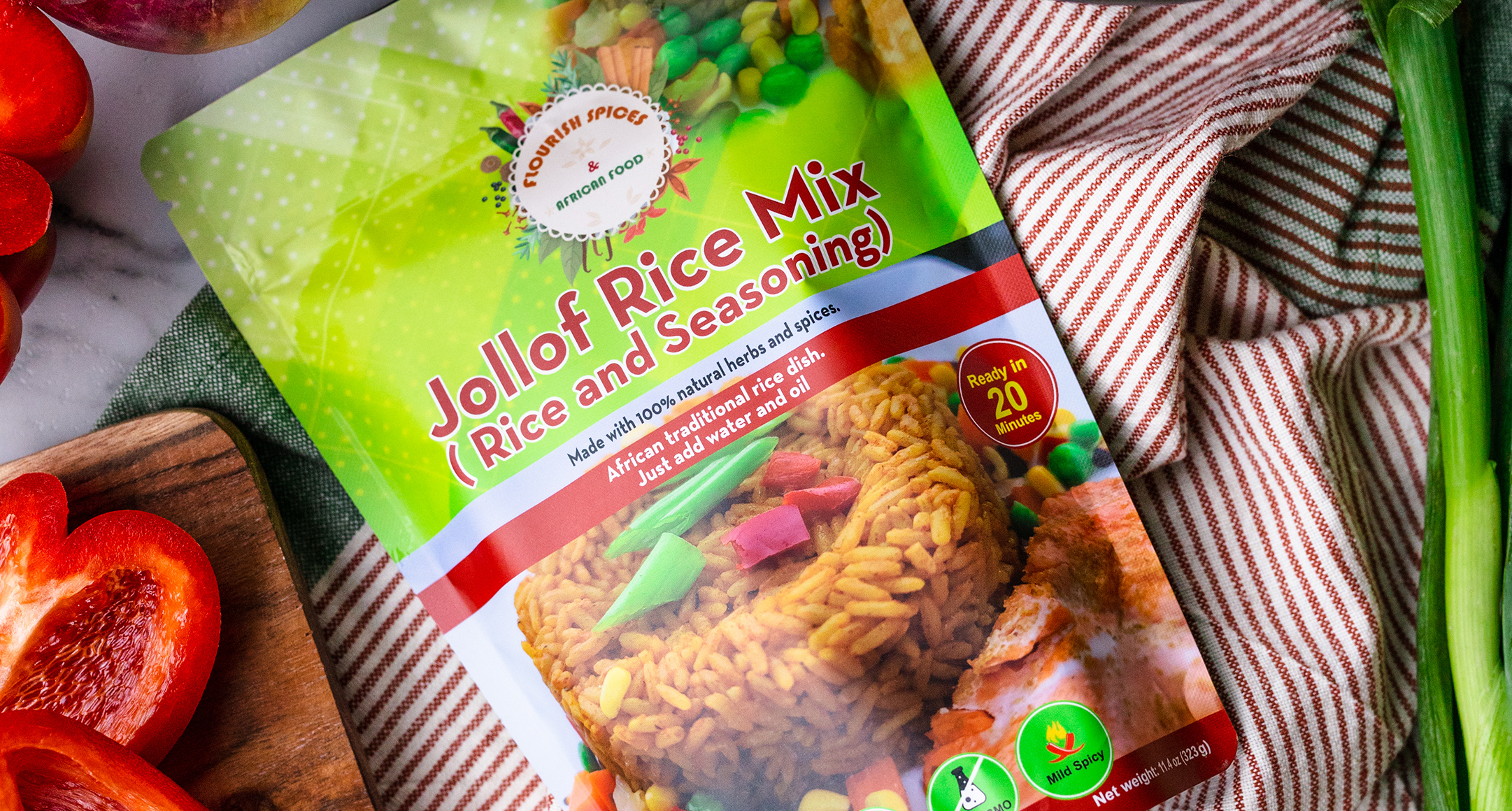 A colorful package of jollof rice mix laying on striped fabric. 