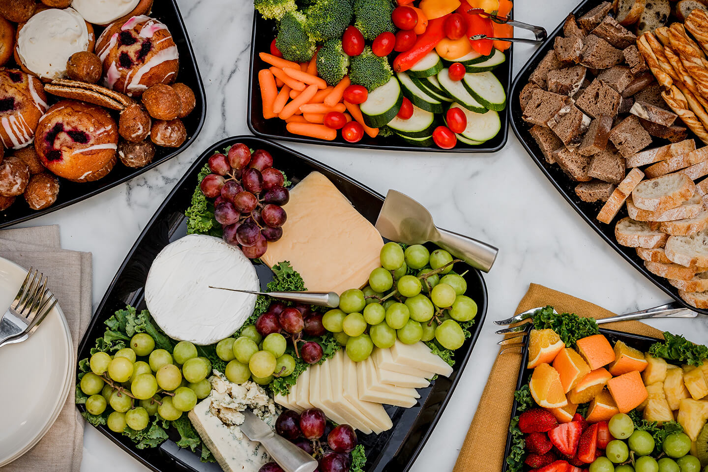a variety of platters including fresh fruit, fresh veggies and charcuterie