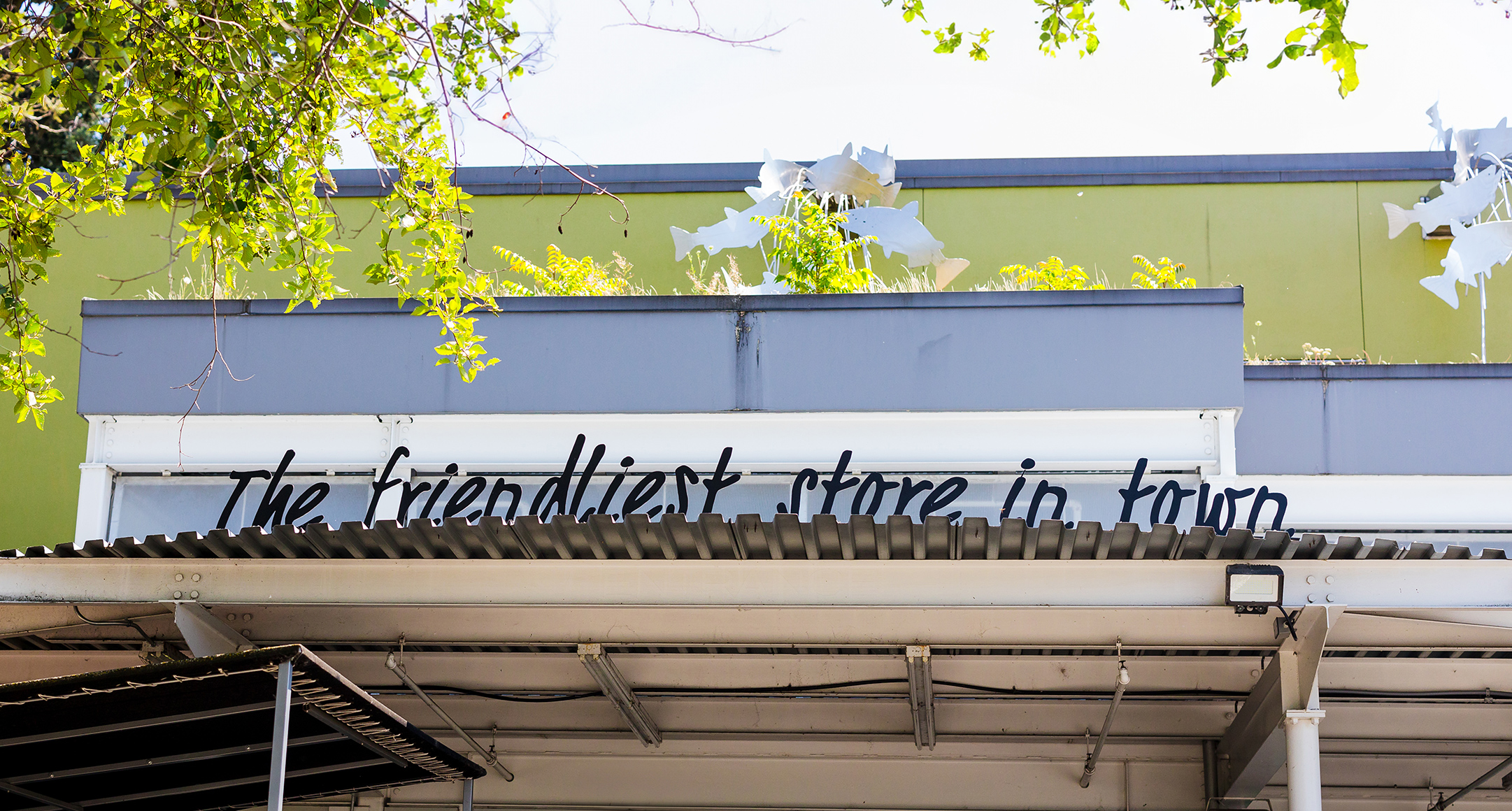 An image showing the exterior of a New Seasons store with lettering that reads: The friendliest store in town. 
