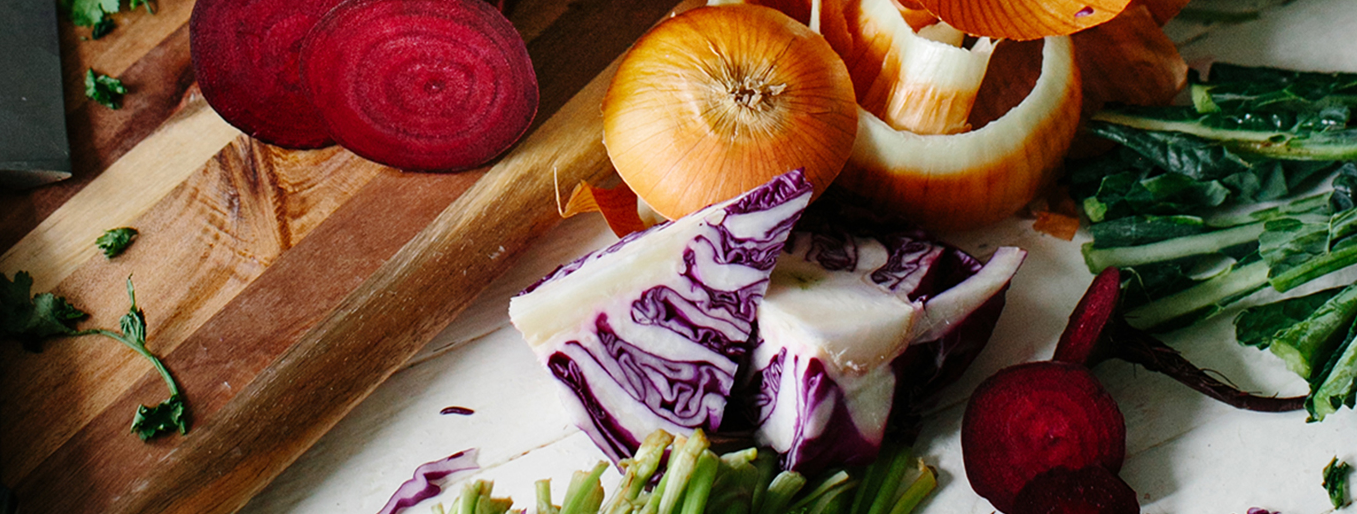 various cut vegetables on a cutting board and countertop