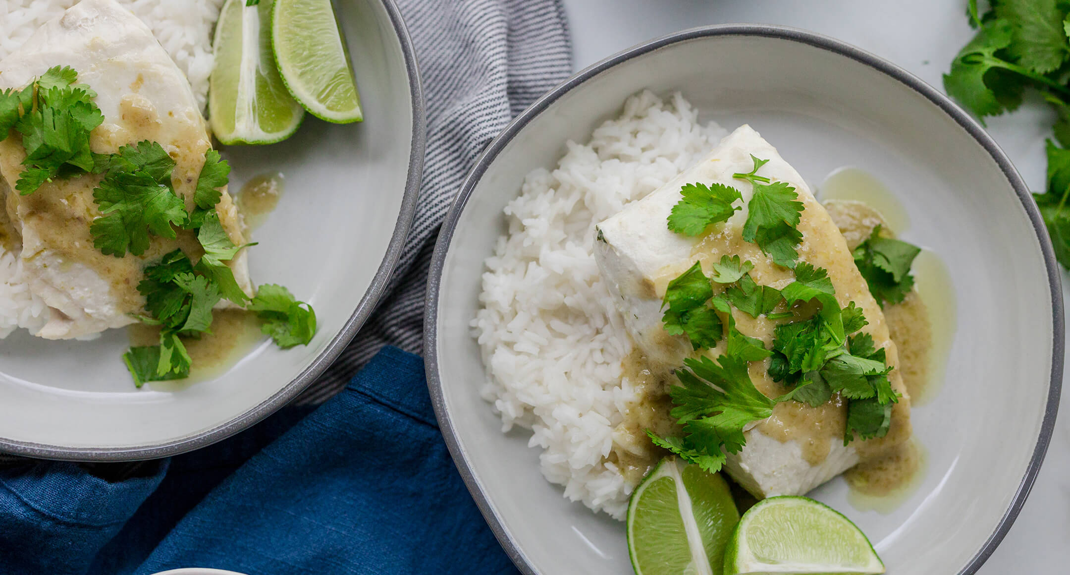 Coconut poached halibut served with rice on a plate.