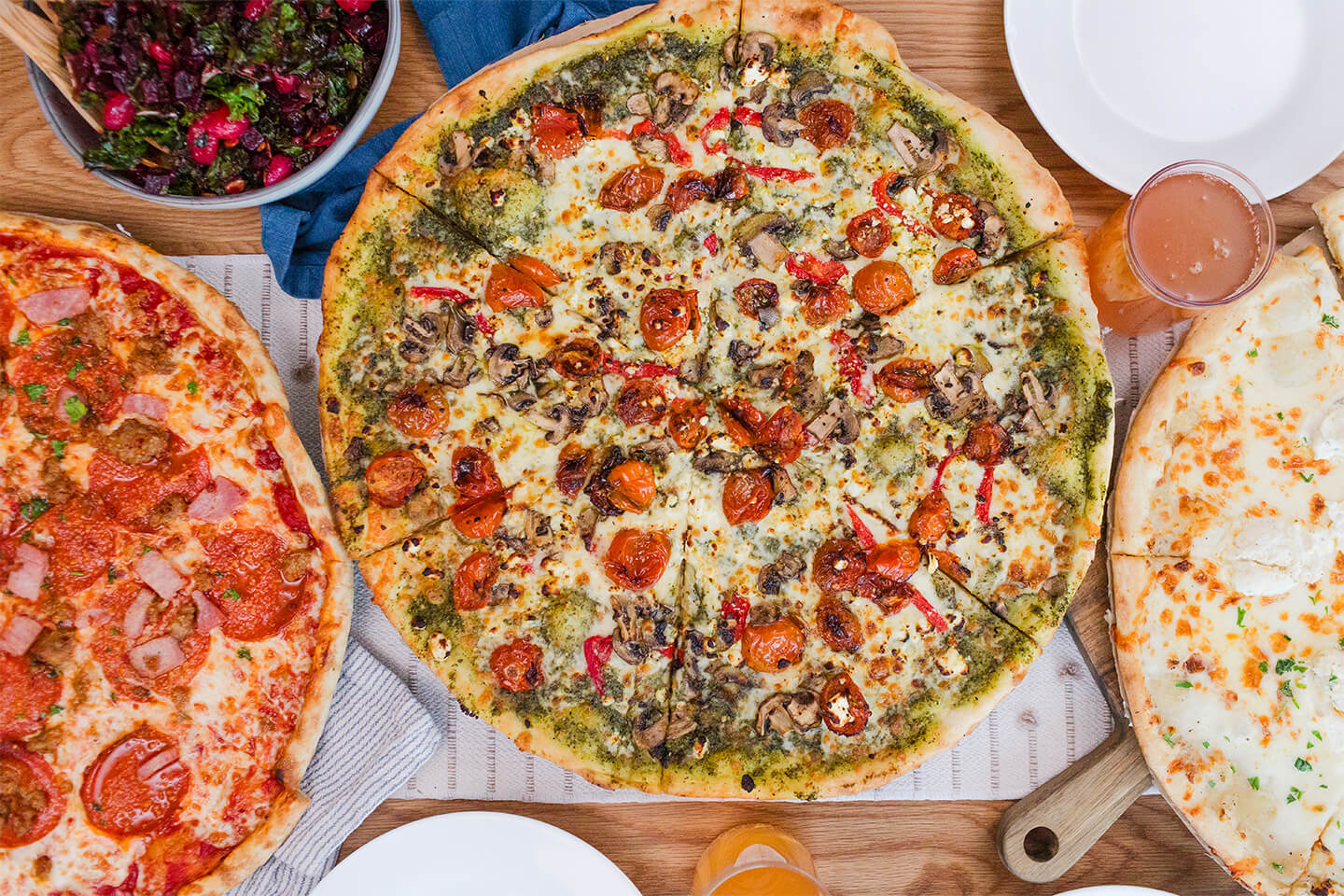 A slice of pepperoni pizza on a plate next to a side salad.