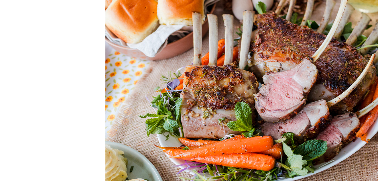 Top down image of a rack of lamb with carrots in a platter