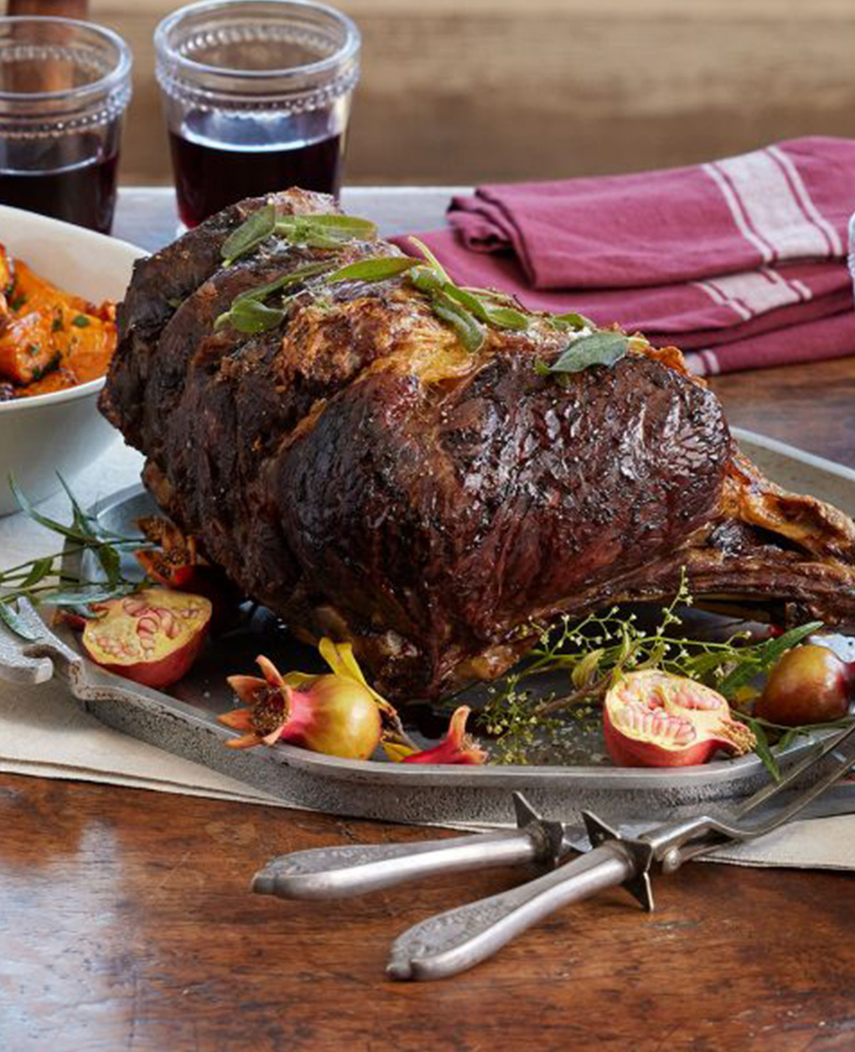 A holiday table set with roasted turkey and traditional sides. 