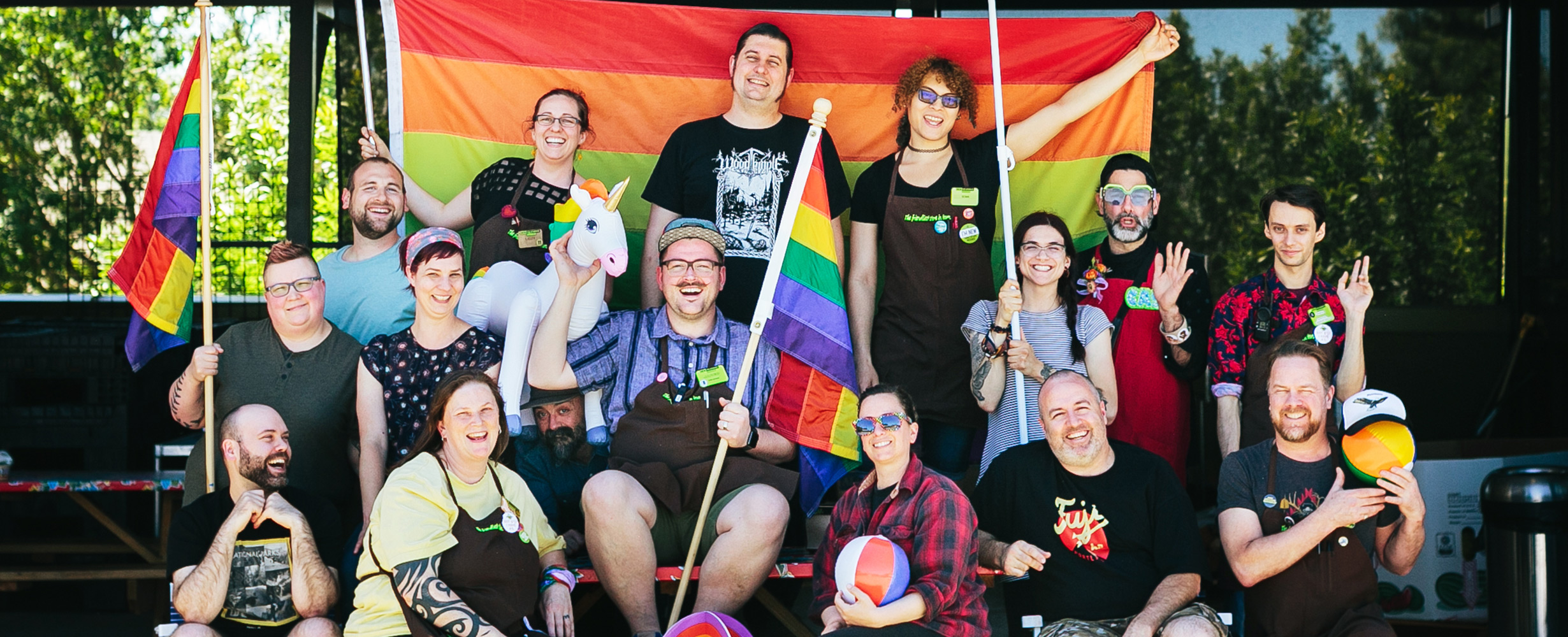 smiling new seasons market staff celebrating pride month with rainbow flags