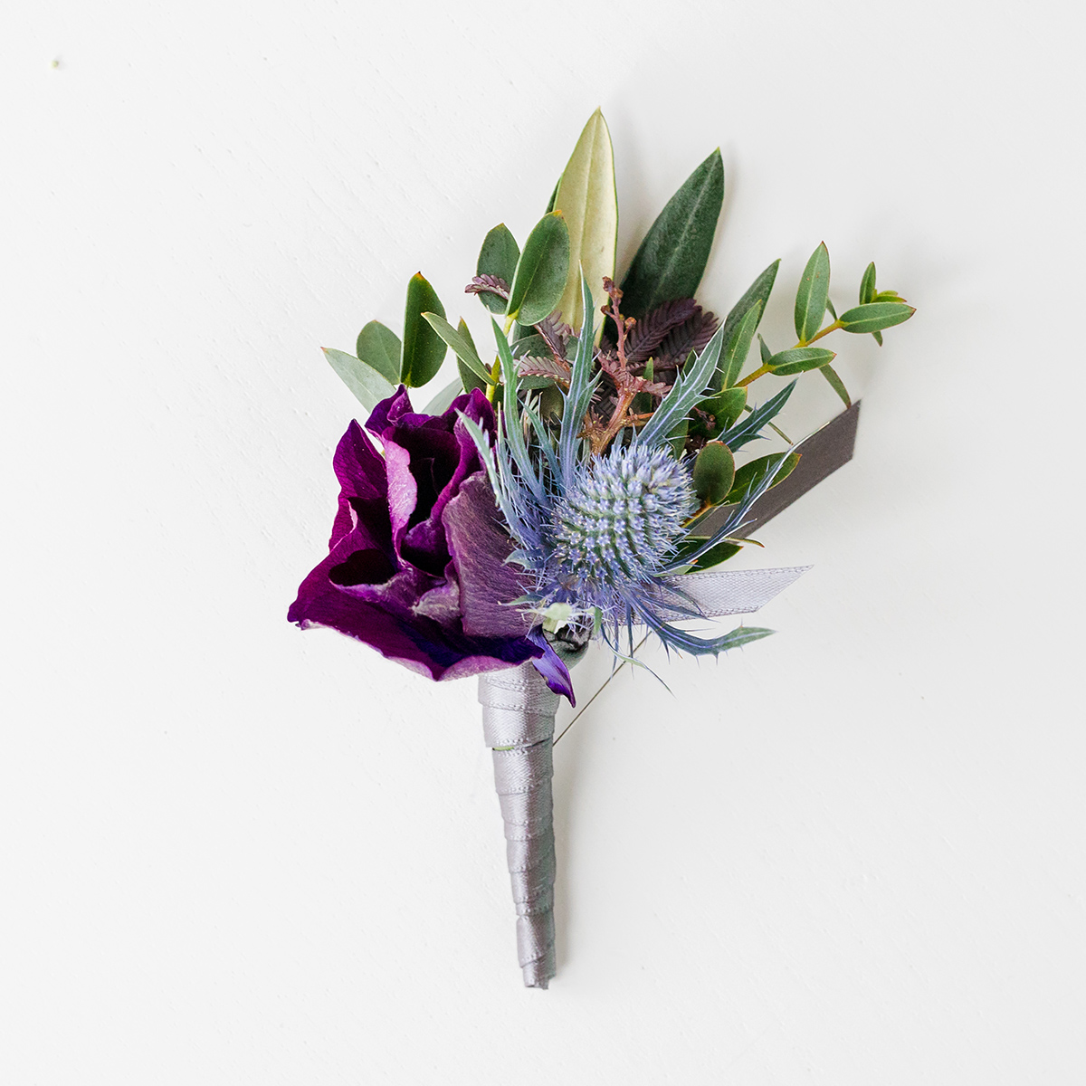 purple, blue and green floral boutonniere