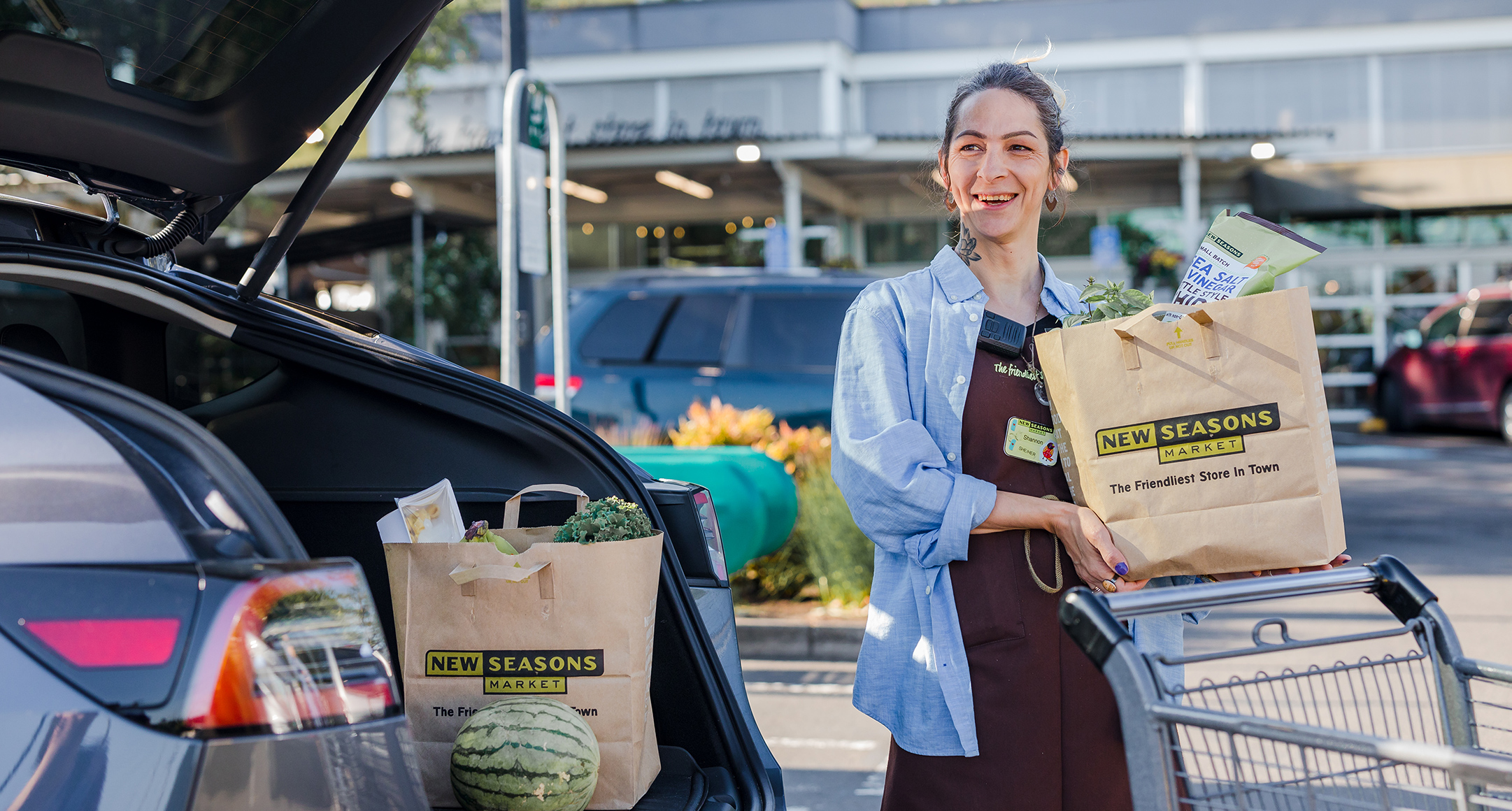 In-store shopper loading groceries into a car trunk