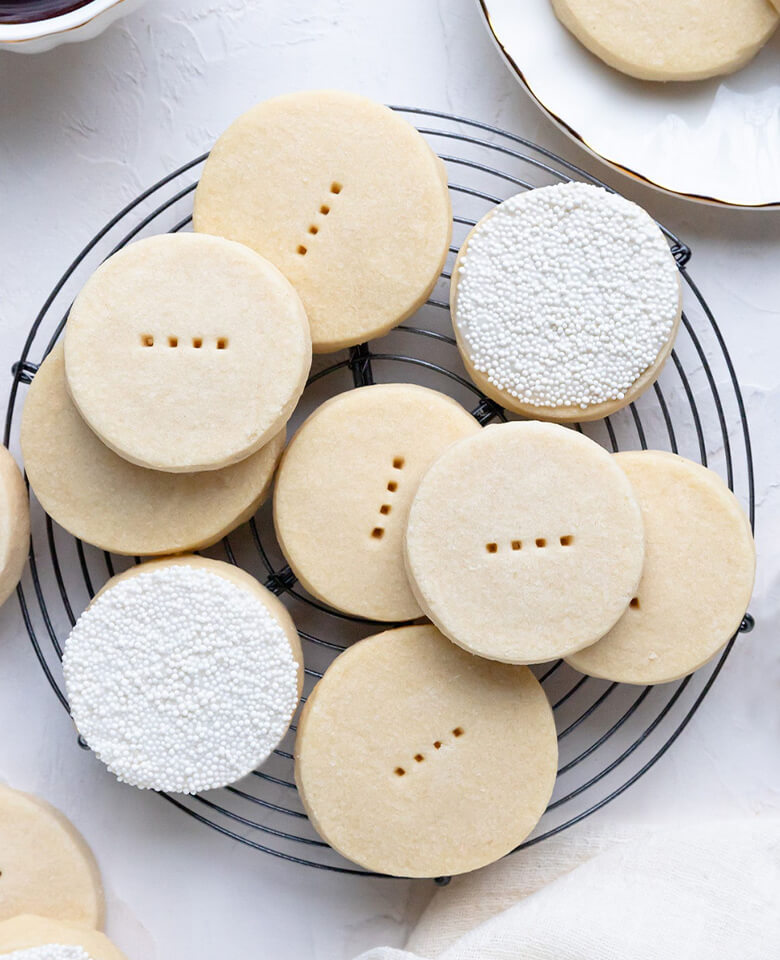Shortbread cookies, some with sprinkles, arranged on a round cooling rack