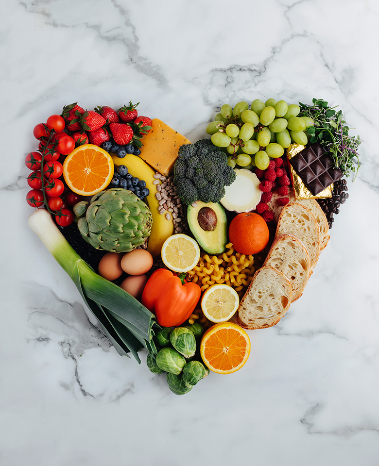 Food arranged in the shape of a heart on a marble backdrop