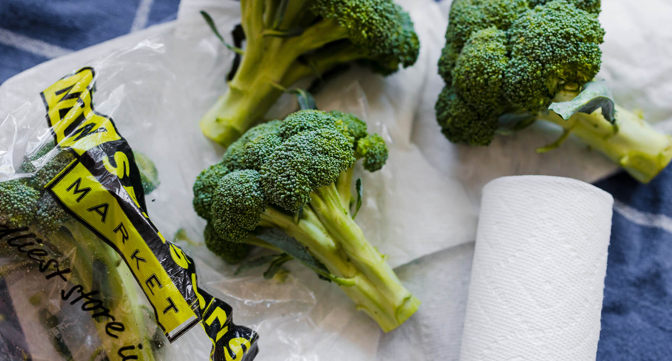 Fresh broccoli next to a New Seasons produce bag.