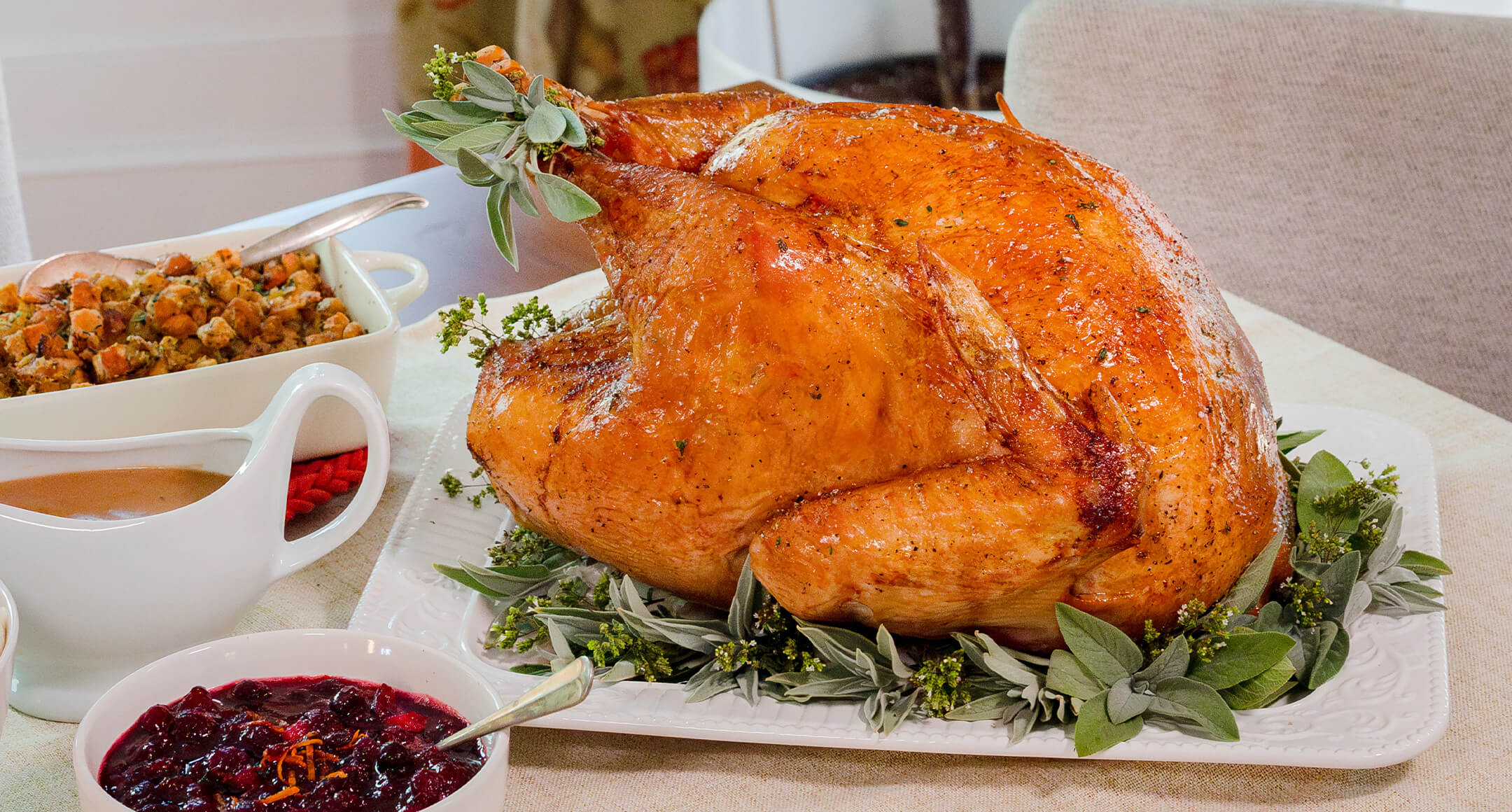 A festive holiday meal with roasted turkey, cranberry sauce, mashed potatoes, bread stuffing, gravy, and white wine.