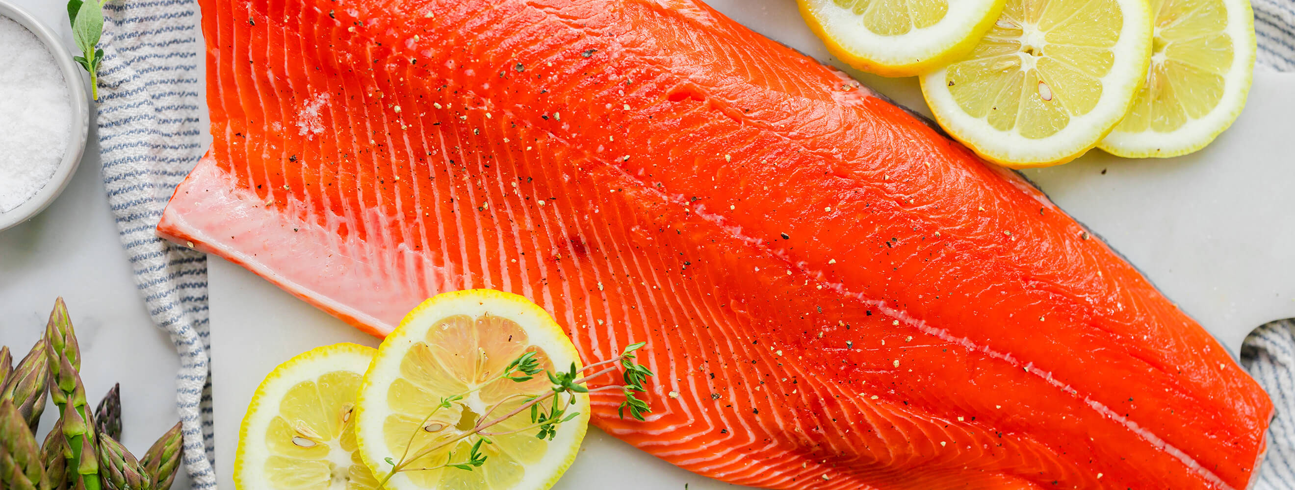 a raw filet of salmon with lemon slices