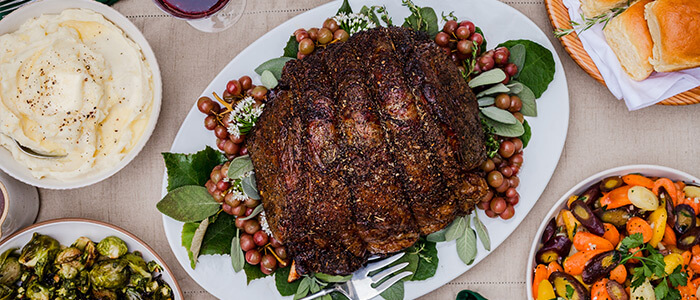 a beef prime rib roast on a holiday platter in an overhead shot