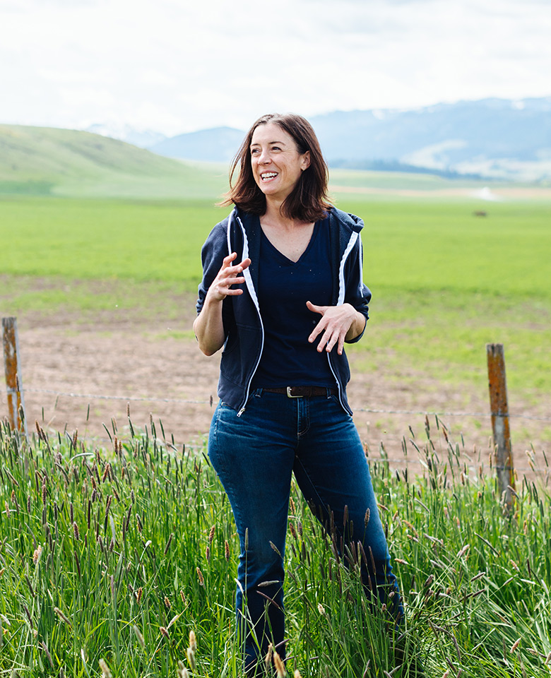 Cory Carman of Carman Ranch standing in grass by a fence