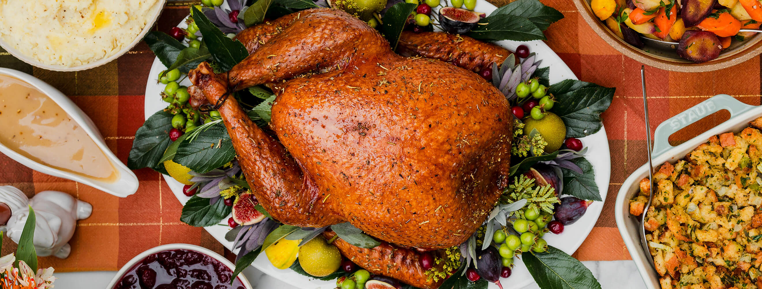 an overhead shot of a roasted turkey in a holiday setting with sides